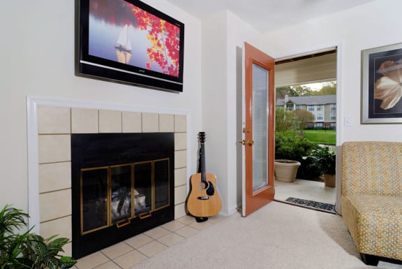 a fireplace with a tv above it and a guitar next to it at Brampton Moors, North Carolina