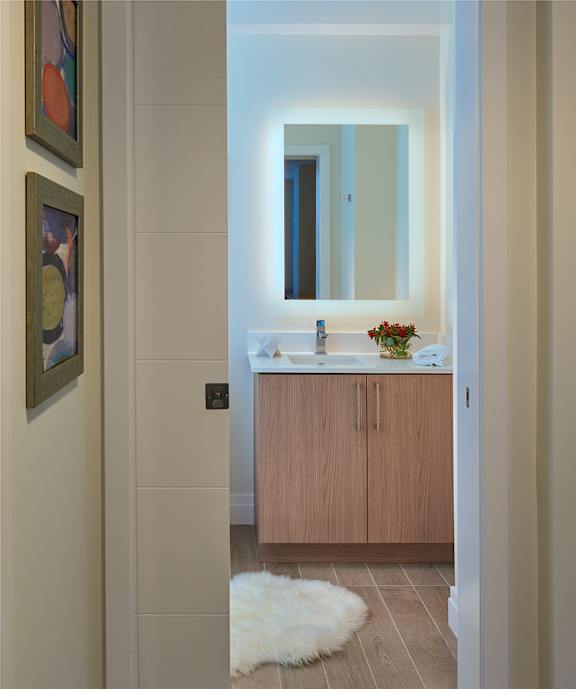 A bathroom with a sink, mirror, and a rug.