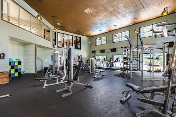 A gym with a variety of equipment including treadmills, weights, and exercise machines.