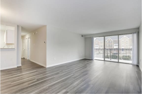 an empty living room with sliding glass doors to a balcony at Avondale Overlook, Hyattsville