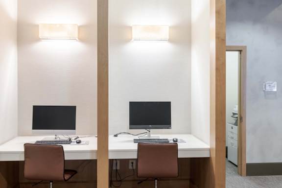 Two desks with computers and chairs in a room