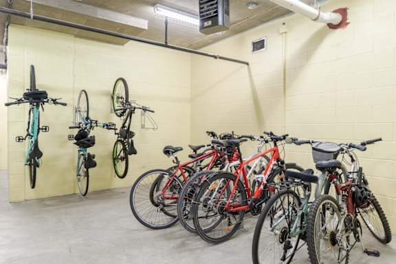 A bike rack with bikes of various colors and sizes