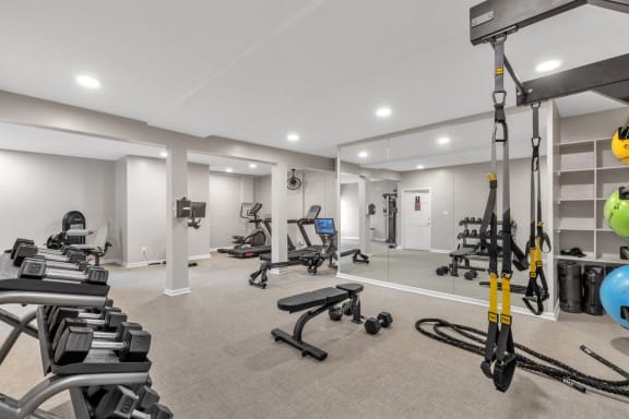 a gym with weights and cardio equipment in a room with white walls  at Brampton Moors, Cary, NC