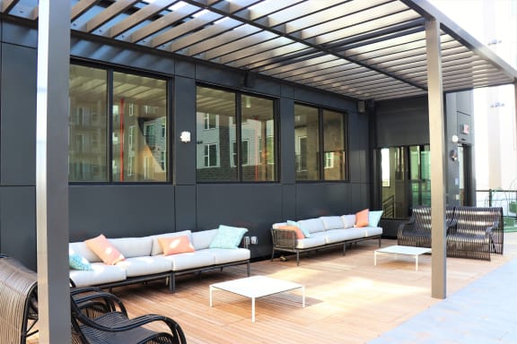 a patio with couches and table at Vyne One Loudoun Apartments in Ashburn, VA