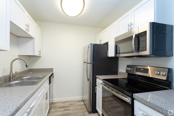 a kitchen with white cabinets and black appliances at St. Andrews Reserve, Wilmington, NC, 28412