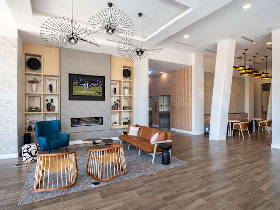 A living room with a television, a fireplace, and a blue chair.