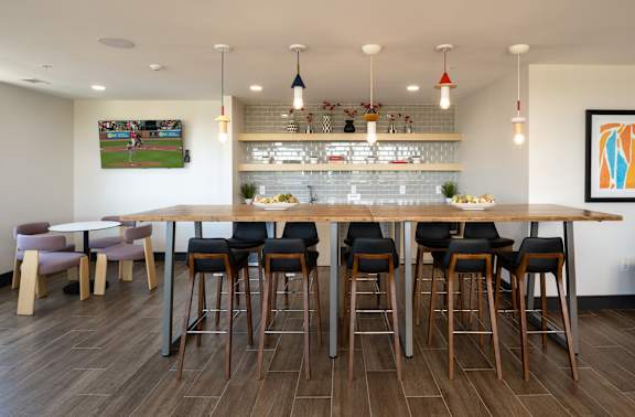 A bar area with a long wooden table and chairs.