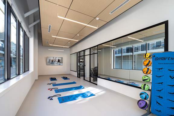 A yoga studio with blue mats and a sign that says "Smart Fitness".