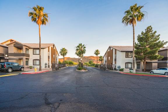 A street view of a residential area with houses and palm trees at Sterling Point Apartment Homes, Phoenix, 85042