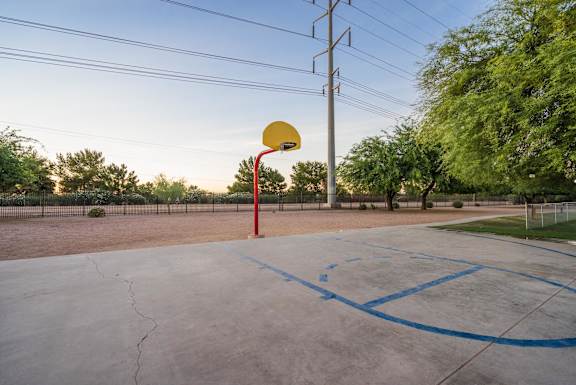 A basketball court with a hoop and blue lines on the ground at Sterling Point Apartment Homes, Arizona