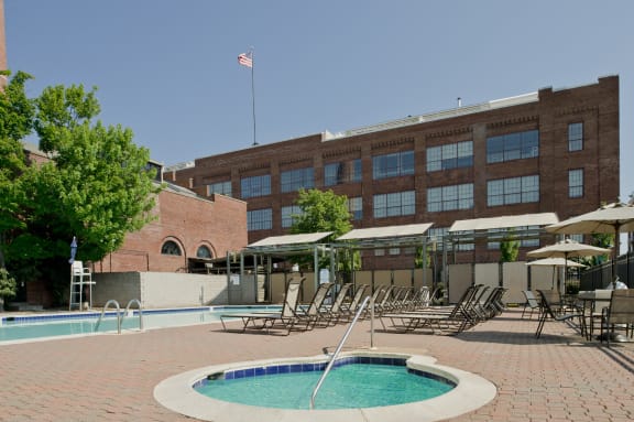 a swimming pool with chairs and a building in the background at Tindeco Wharf, Maryland, 21224