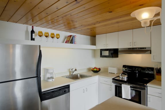 a kitchen with white cabinets and a stainless steel refrigerator at Tindeco Wharf, Maryland
