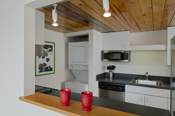 a kitchen with white cabinets and a sink and a microwave at Tindeco Wharf, Maryland, 21224