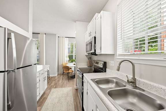 A modern kitchen with a stainless steel refrigerator and a granite countertop.