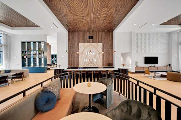 A modern living room with a wooden ceiling and a large abstract painting on the wall.