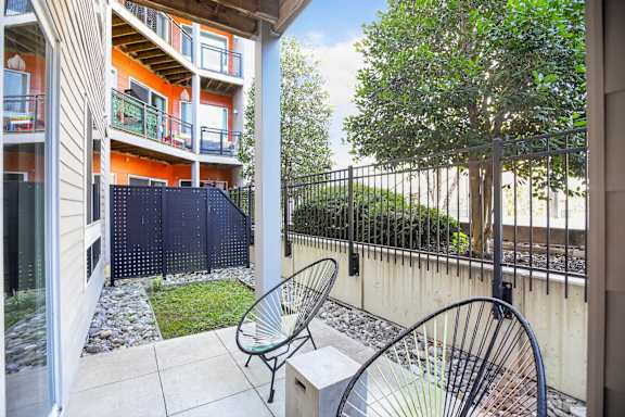 A patio with a chair and a table is shown.