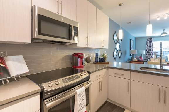 A kitchen with white cabinets and a stainless steel oven.at The Aster Cary, North Carolina