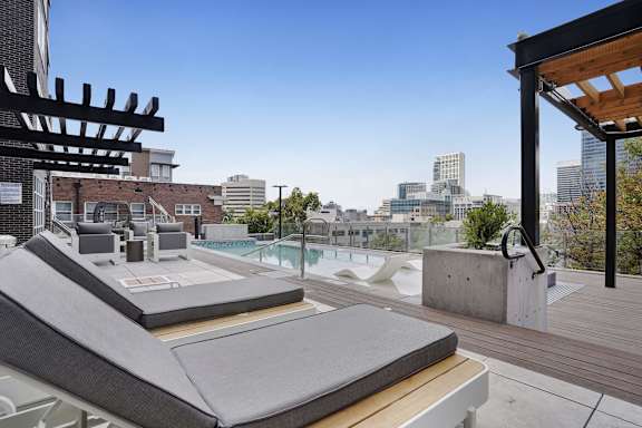 A rooftop patio with a pool and lounging area at Lotus Republic Apartments, Utah