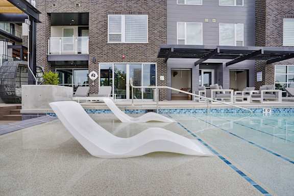 A modern pool with a white sculpture in the middle of it at Lotus Republic Apartments, Utah