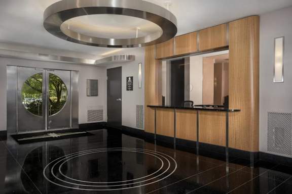 A modern hallway with a glass door and a wooden panel wall.