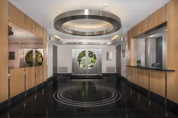 A modern hallway with a black floor and wooden walls.