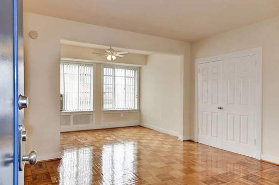 A room with a wooden floor and a ceiling fan.