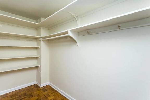 Walk-in closet with shelving and hanging rods at Empire Apartments, Washington, District of Columbia