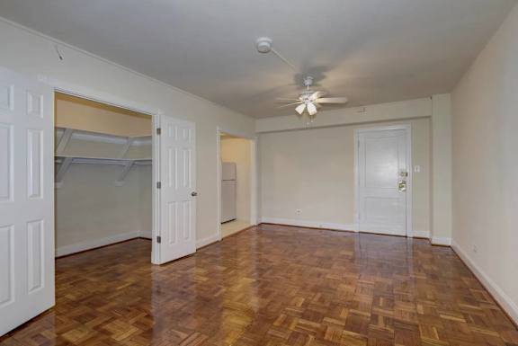 A room with a ceiling fan and wooden flooring.
