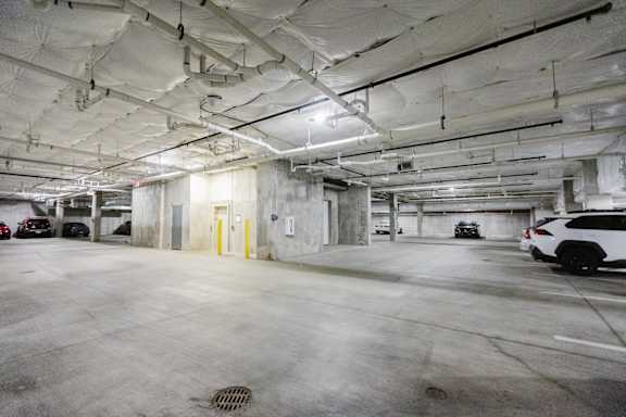 A parking garage with a white car parked in the foreground.