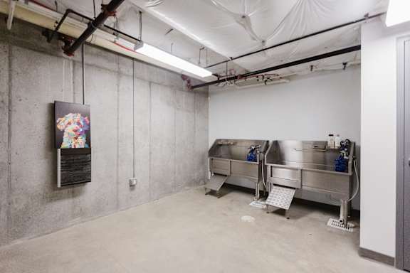 A large industrial room with a stainless steel tank and a poster on the wall.