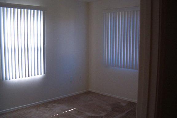 A room with a window on the left and a window on the right.