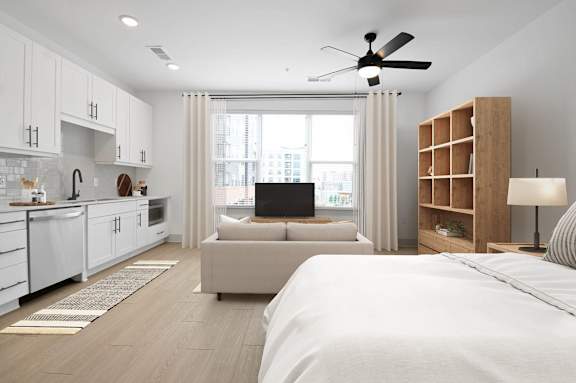 a bedroom with a bed and a couch in front of a window at Metropolitan at the Riverwalk, Wilmington, NC
