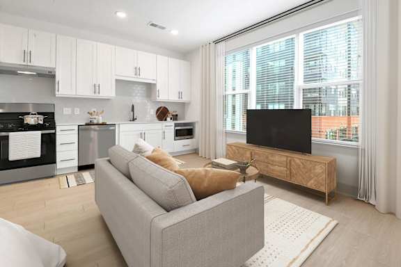 a living room with a couch and a tv at Metropolitan at the Riverwalk, Wilmington, NC