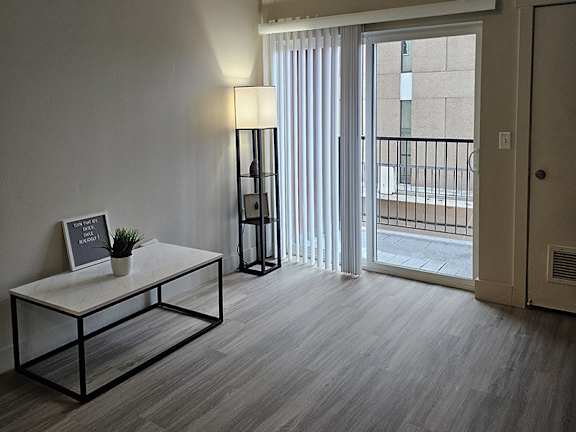 A room with a table, a lamp, and a plant.