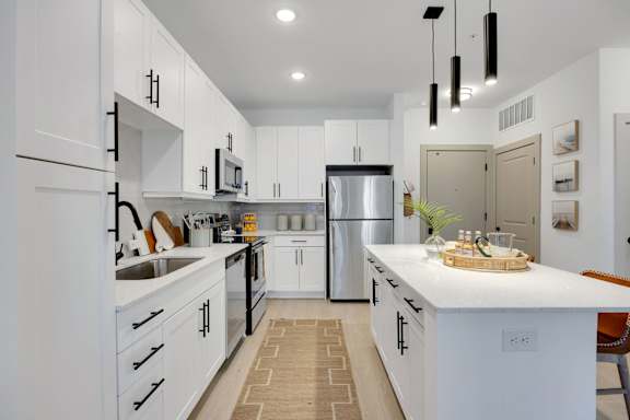 A modern kitchen with white cabinets and a central island.