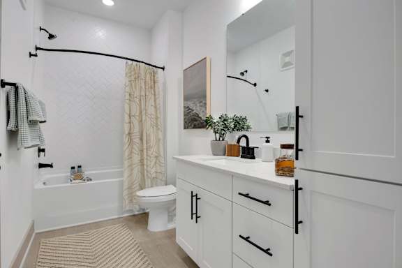 A white bathroom with a toilet, sink, and a shower curtain.