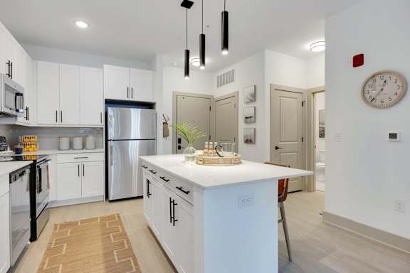 A modern kitchen with white cabinets and a central island.