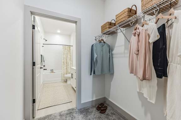 A white bathroom with a white door and a white wall.