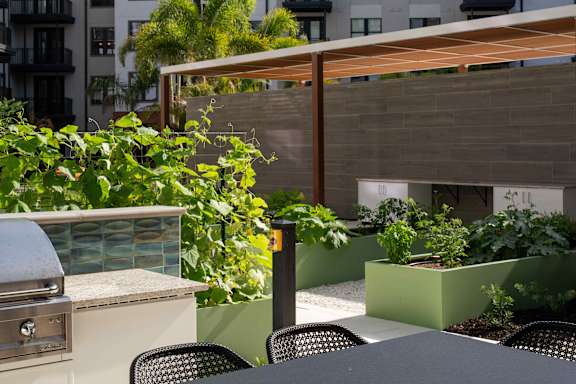 A patio with a grill and chairs.