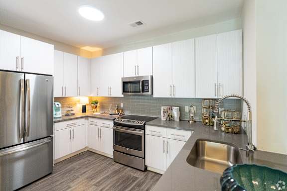 A modern kitchen with stainless steel appliances and white cabinets.