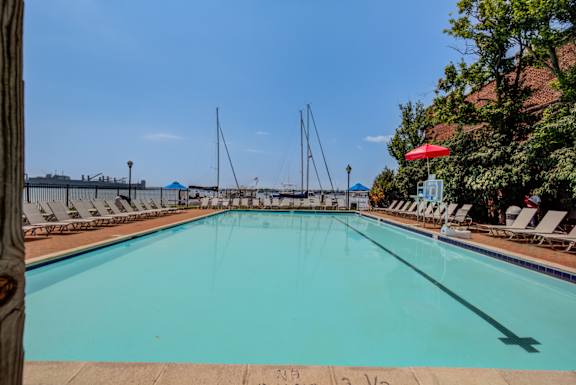 A large swimming pool with sun loungers and umbrella at Tindeco Wharf, Baltimore, MD 21224