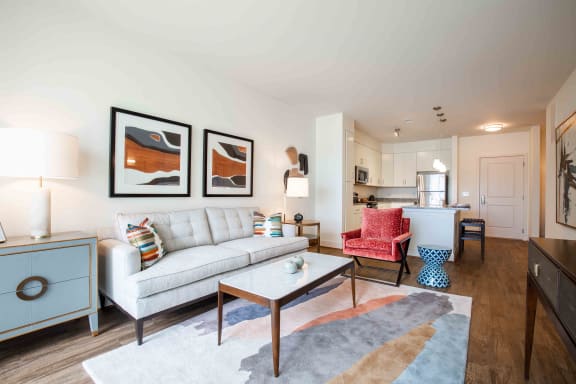 a living room with a couch and a table at Woodmore Grand Apartments in Bowie, MD 20721