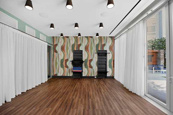 A room with a wooden floor and a striped wallpaper.