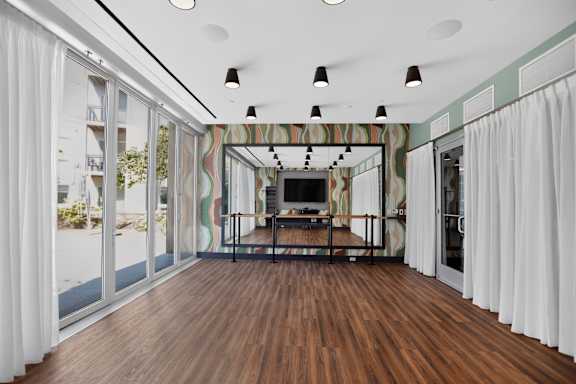 A room with a wooden floor and a striped wallpapered wall.