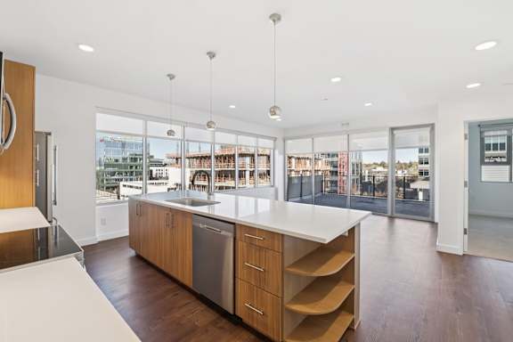 A modern kitchen with a large island and wooden cabinets.