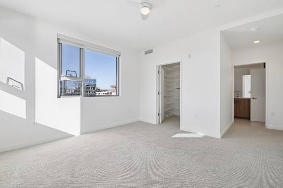 A large empty room with a window overlooking a cityscape.