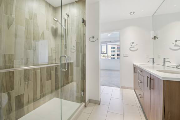 A bathroom with a walk-in shower and double sinks.