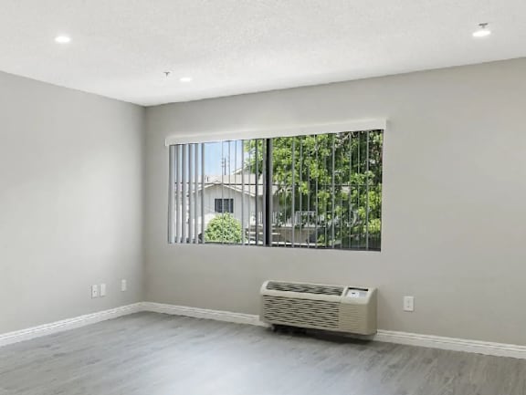 A room with a window and a wall-mounted air conditioner.