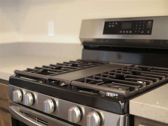 a stainless steel stove top oven sitting next to a counter at Loma Villas Apartments, San Bernardino, 92408