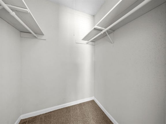 a large closet with white walls and a white closet